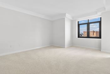 The living room of an empty apartment with a window